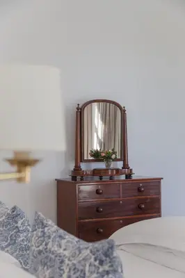 a bedroom with a dresser with a mirror on it at Lily Pond House at Le Lude in Franschhoek