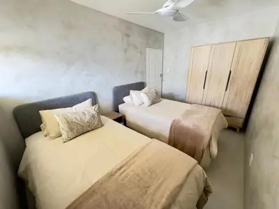 a bedroom with two beds and a cupboard at Casa Praia in Strand