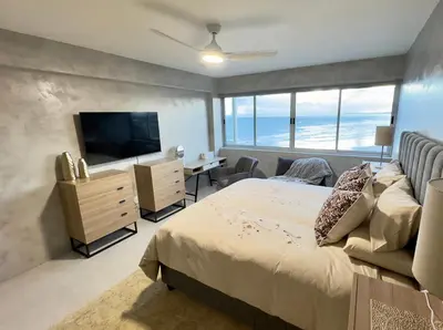a bedroom with a bed and a television and a desk at Casa Praia in Strand