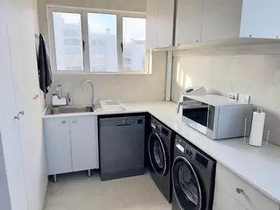 a kitchen with a washing machine and a sink at Casa Praia in Strand