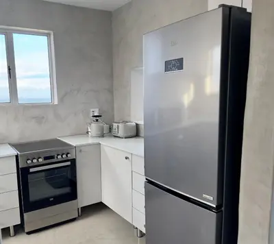 a kitchen with a stainless steel refrigerator and a stove at Casa Praia in Strand