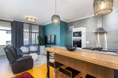 a kitchen with a bar and a living room at Burmeister Circle by CTHA in Cape Town