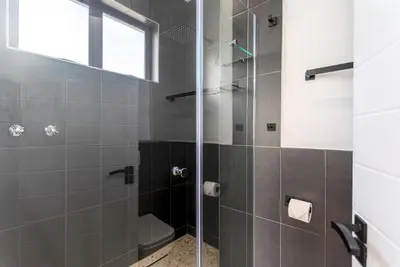 a bathroom with a shower with a glass door at Burmeister Circle by CTHA in Cape Town