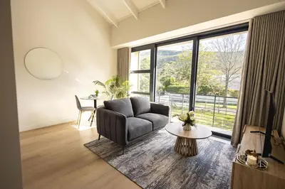 a living room with a couch and a large window at Two Horizons Apartment 6 in Hermanus