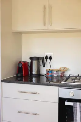 a kitchen counter with a coffee pot on it at Two Horizons Apartment 6 in Hermanus