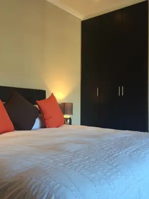 a bedroom with a large bed with red pillows at Topiary Wine Estate & Cottages in Franschhoek