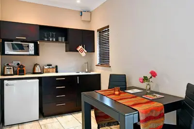 a small kitchen with a table and a counter top at Topiary Wine Estate & Cottages in Franschhoek