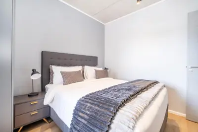 a bedroom with a large bed with a blue blanket at Riverlands - Lux 1 bedroom Apartment with Parking in Cape Town