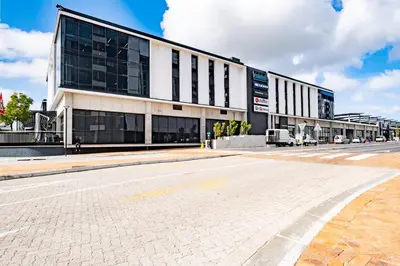 an empty street in front of a large building at Riverlands - Lux 1 bedroom Apartment with Parking in Cape Town