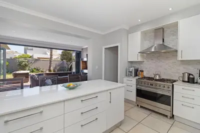 a kitchen with white cabinets and a counter top at Ocean Whisper Terrace Villa in Cape Town