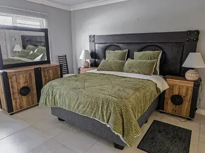 a bedroom with a large bed and a large mirror at Elianta House in Cape Town