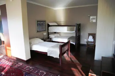 a bedroom with two beds and a staircase in it at Whalesong Villa in Hermanus