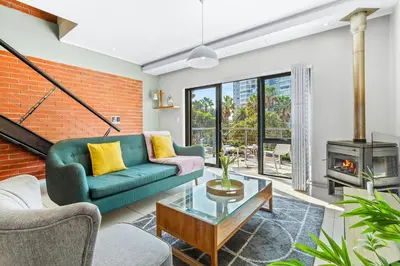 a living room with a couch and a fireplace at Manhattan Wharfside 301 in Cape Town