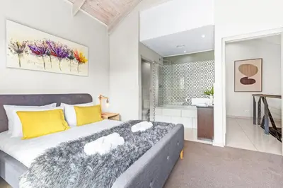 a bedroom with a large bed and a bathroom at Manhattan Wharfside 301 in Cape Town