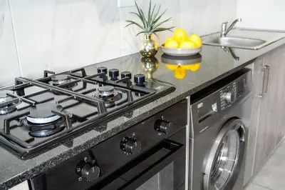 a stove top oven in a kitchen with a sink at The Orion 18 in Table View