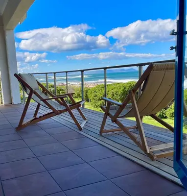 a hammock on a balcony with a view of the ocean at Pitkindie Oceanfront Escape in Hermanus