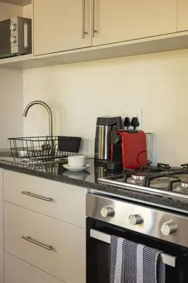a kitchen with a stove and a red appliance at Heaven & Earth Apartment 8 in Hermanus