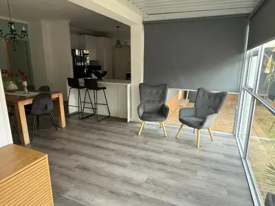 a living room with two chairs and a table at Mopanie House in Brackenfell