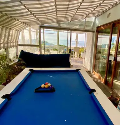 a pool table in the middle of a living room at Sea and Sky Rooiels in Rooiels