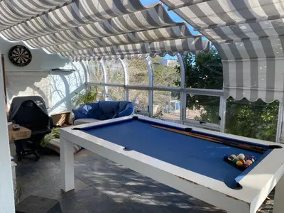 a pool table in a room with awning at Sea and Sky Rooiels in Rooiels