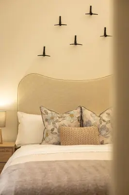 a bedroom with a bed with birds on the wall at Valley's Embrace Apartment 7 in Hermanus