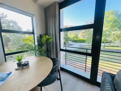 a dining room with a table and a large window at Valley's Embrace Apartment 7 in Hermanus