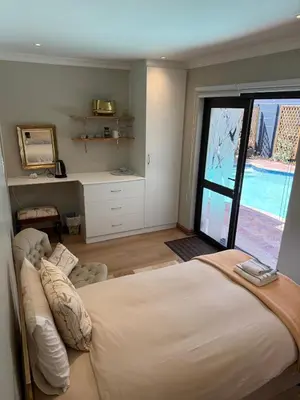 a bedroom with a large bed and a large window at Shire Lodge in Cape Town