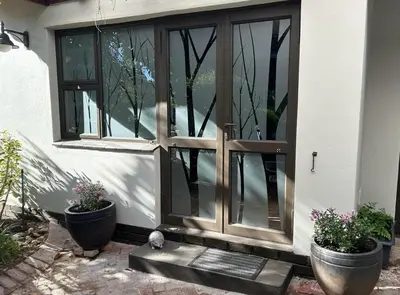 a door to a house with two potted plants at Shire Lodge in Cape Town