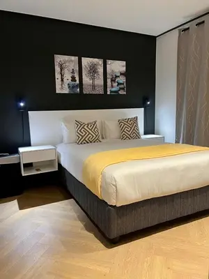 a bedroom with a large bed with three pictures on the wall at The CoziPlace Lux in Cape Town
