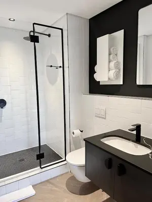 a bathroom with a shower and a toilet and a sink at The CoziPlace Lux in Cape Town