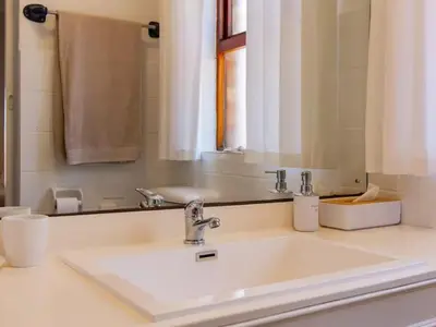 a bathroom with a sink and a mirror at Whales & Wonders Guesthouse in Hermanus