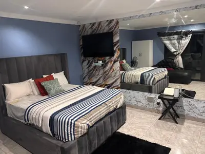 a bedroom with two beds and a flat screen tv at Browns villa and construction pty ltd in Cape Town