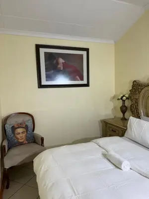 a bedroom with a bed and a picture on the wall at Harmony Lodge in Elsiesrivier