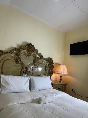 a bedroom with a large bed with a large headboard at Harmony Lodge in Elsiesrivier