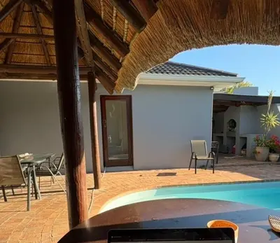 a patio with a swimming pool and a table and chairs at Joy House in Cape Town