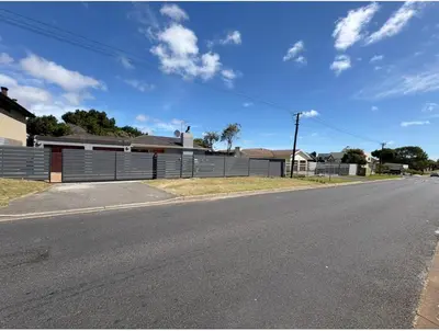an empty street in front of a fence at Joy House in Cape Town