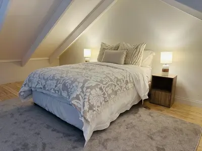 a bedroom with a large bed and two lamps at Aurora Valley Escape Apartment 9 in Hermanus