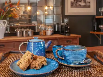 a table with two blue cups and two plates with bread at Leopard Lodge in Hermanus
