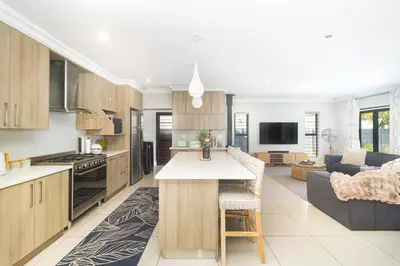 an open kitchen and living room with a couch at Peppertree Villa in Brackenfell