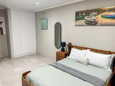 a bedroom with a bed and a painting on the wall at Blade Flatlet 2 in Silver Sands