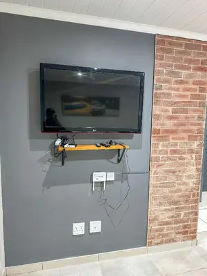 a wall with a flat screen tv on a wall at Blade Flatlet 2 in Silver Sands