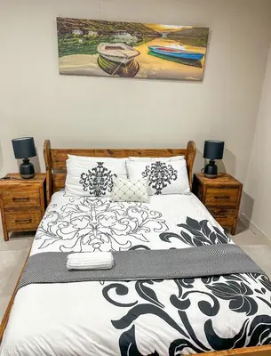 a bedroom with a black and white bed with two lamps at Blade Flatlet 2 in Silver Sands