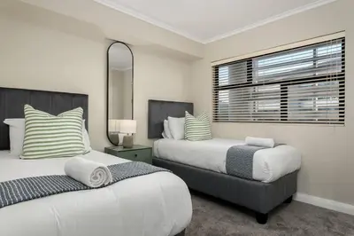 a bedroom with two beds and a window at Modern 2 Bed Century City Apartment, Pool and Braai in Cape Town