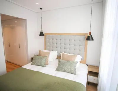 a bedroom with a large white bed with three pillows at Charming Apartment in Cape Winelands District in Stellenbosch