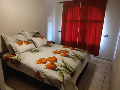 a bedroom with a bed with flowers on it at Schubert Self Catering Accomodation in Brackenfell