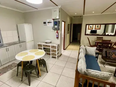 a kitchen and living room with a table and a couch at Rivergrace Farm in Robertson