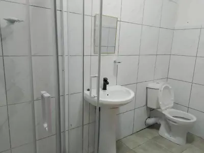 a white bathroom with a toilet and a sink at Guest Lodge on 12 Duminy in Bellville