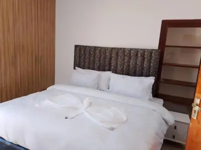 a white bed with a white bow on it at Guest Lodge on 12 Duminy in Bellville