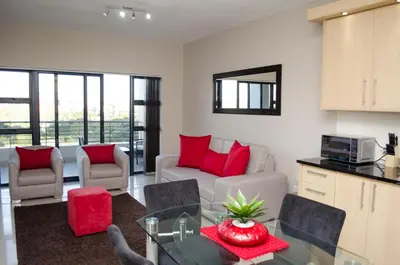 a living room with red pillows on a couch at Knightsbridge Luxury Apartments in Cape Town