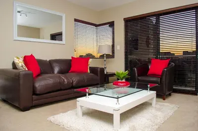 a living room with a leather couch and a coffee table at Knightsbridge Luxury Apartments in Cape Town